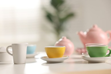 Photo of Tea set on white table indoors, closeup with space for text. Child's toy