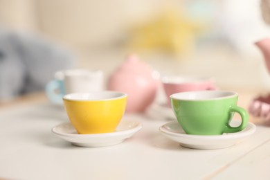Photo of Tea set on white table indoors, closeup with space for text. Child's toy