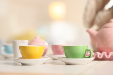 Photo of Tea set on white table indoors, closeup with space for text. Child's toy
