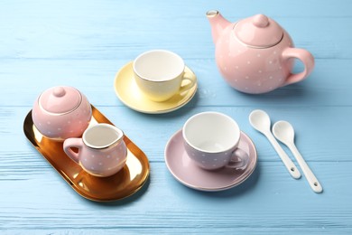 Photo of Beautiful ceramic tea set for children on light blue wooden table