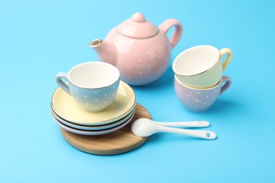 Photo of Beautiful ceramic tea set for children on light blue background