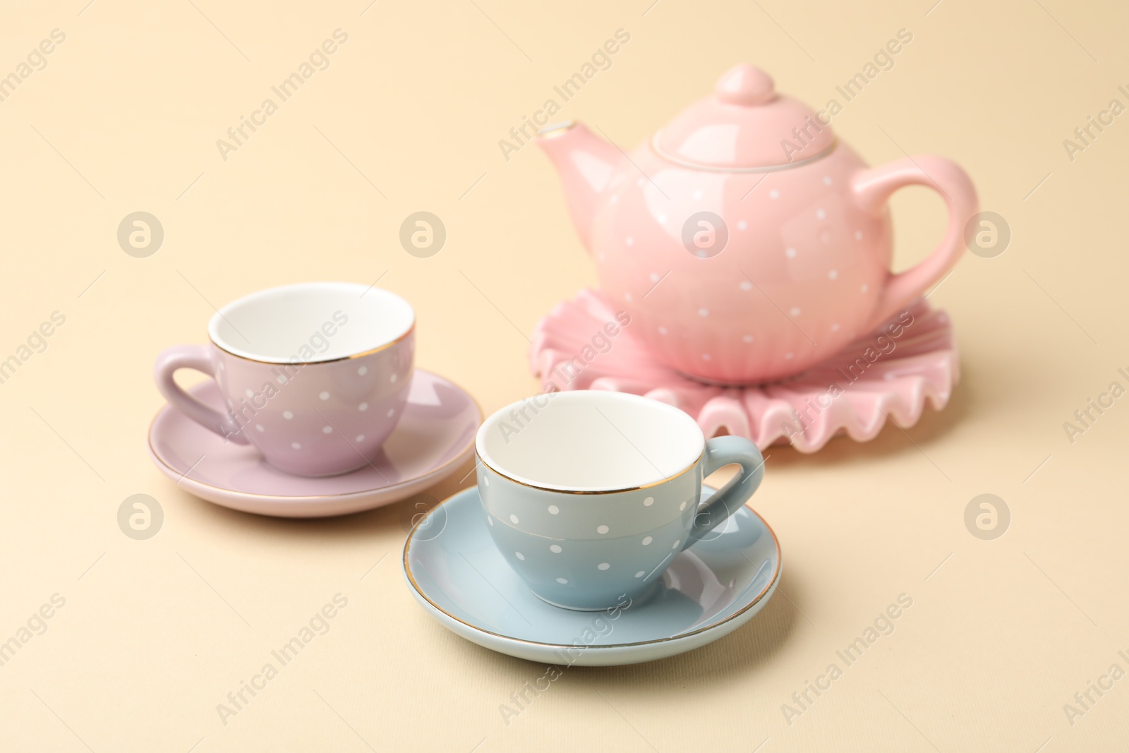 Beautiful ceramic tea set for children on beige background, closeup Photo of Beautiful ceramic tea set for children on beige background, closeup