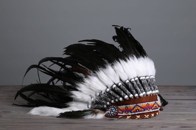 Photo of Native American chief headdress (feathered war bonnet) on wooden surface against light background