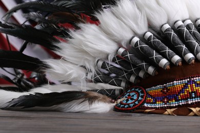 Photo of Native American chief headdress (feathered war bonnet) on wooden surface, closeup