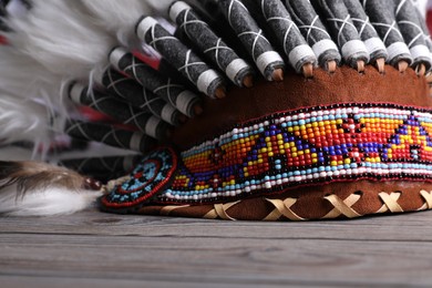 Photo of Native American chief headdress (feathered war bonnet) on wooden surface, closeup