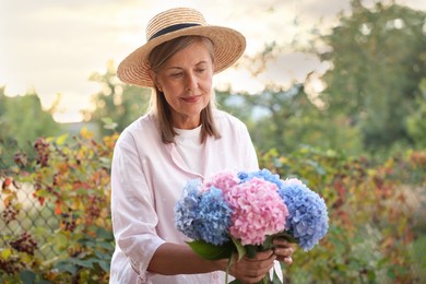 Photo of Senior woman with beautiful bouquet of flowers in garden