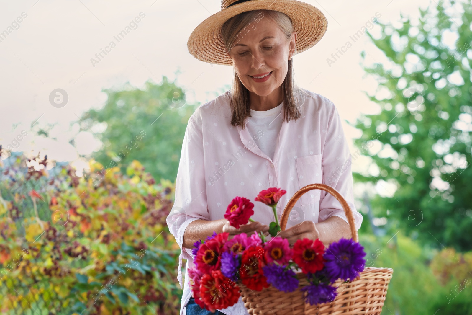 Photo of Senior woman making beautiful bouquet of flowers in garden