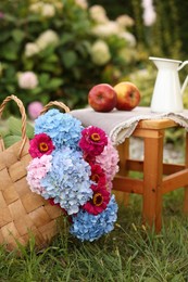 Photo of Beautiful bouquet of flowers, apples and jug in garden