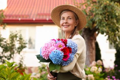Photo of Senior woman with beautiful bouquet of flowers in garden