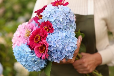 Photo of Senior woman with beautiful bouquet of flowers in garden, closeup