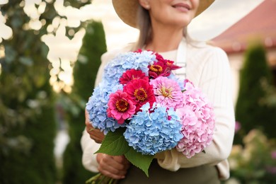 Photo of Senior woman with beautiful bouquet of flowers in garden, closeup
