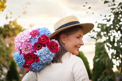 Photo of Senior woman with beautiful bouquet of flowers in garden