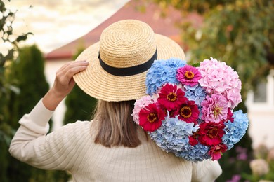 Photo of Senior woman with beautiful bouquet of flowers in garden, back view