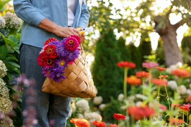 Photo of Senior woman with beautiful bouquet of flowers and pruner in garden, closeup