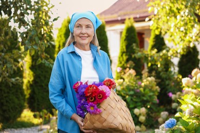 Photo of Senior woman with beautiful bouquet of flowers in garden