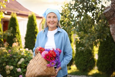 Photo of Senior woman with beautiful bouquet of flowers in garden