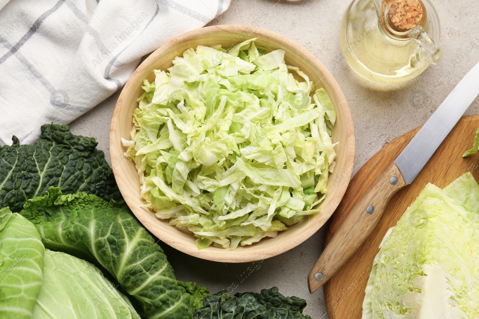 Photo of Fresh Savoy cabbages, knife and oil on light table, flat lay