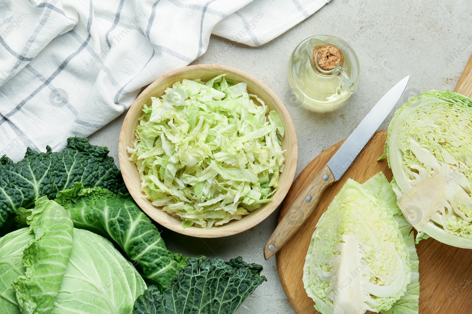 Photo of Fresh Savoy cabbages, knife and oil on light table, flat lay