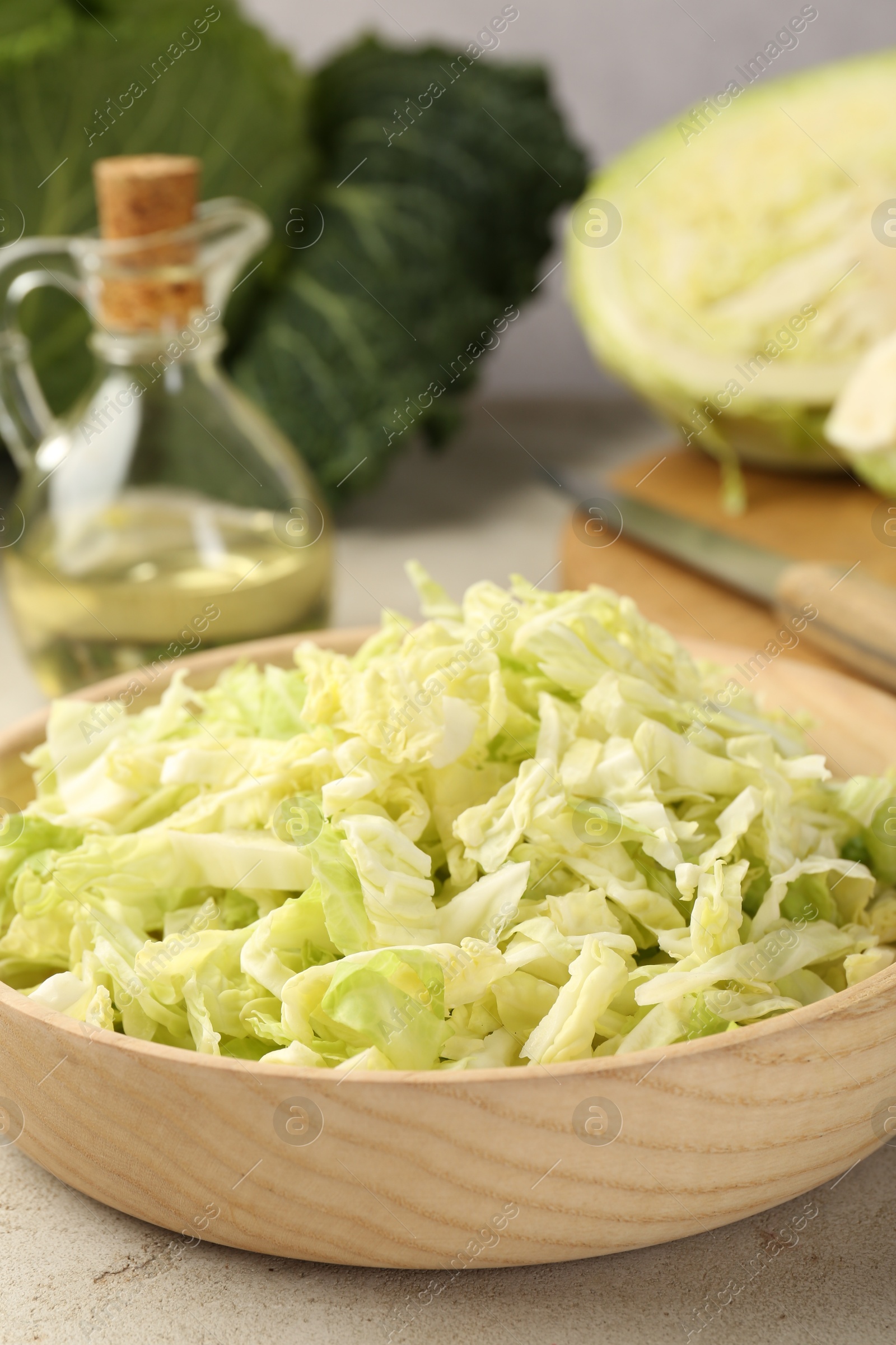 Photo of Shredded Savoy cabbage in bowl on light table, closeup