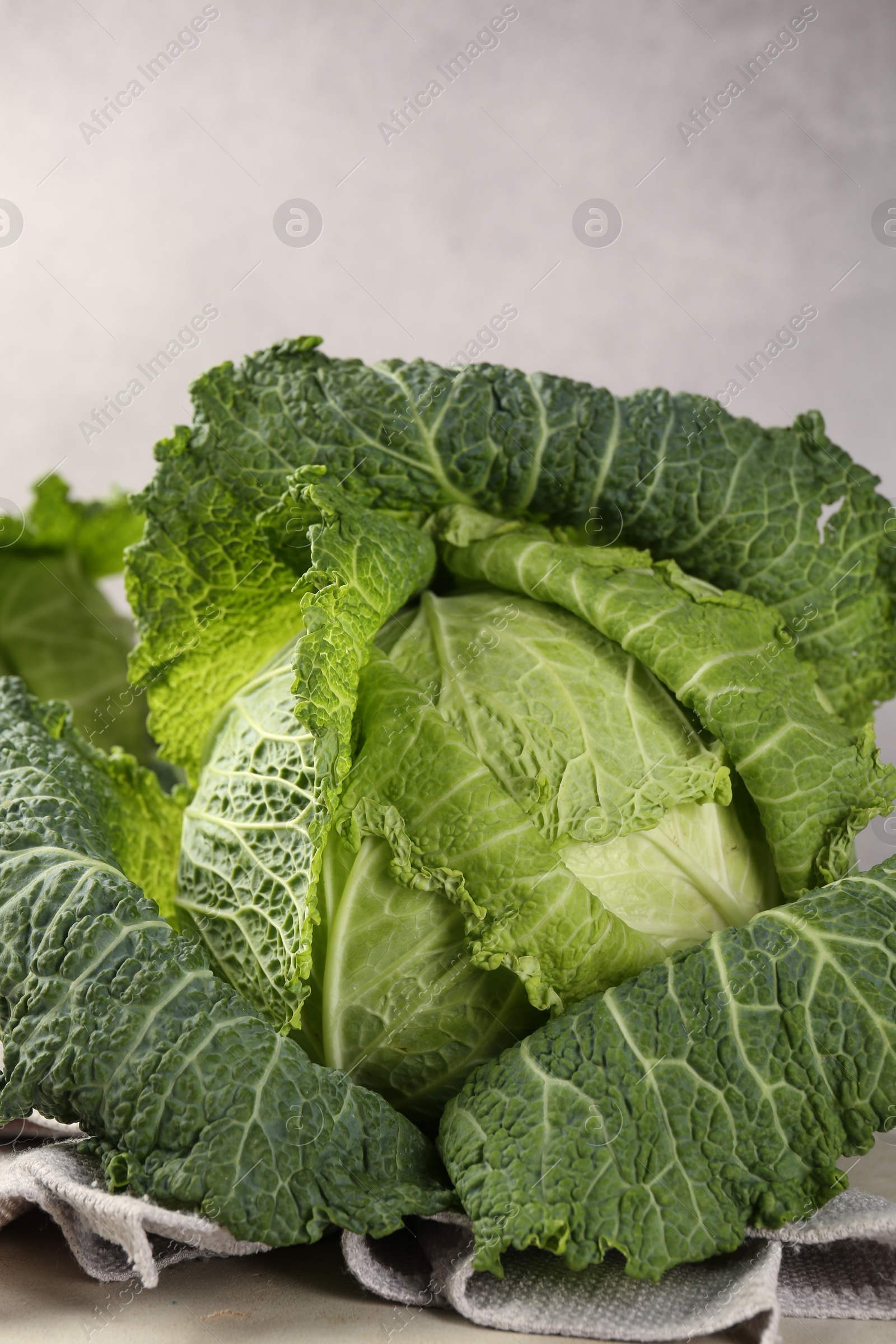 Photo of Fresh Savoy cabbages on light grey table, closeup