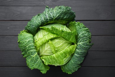 Photo of Fresh Savoy cabbage on black wooden table, top view