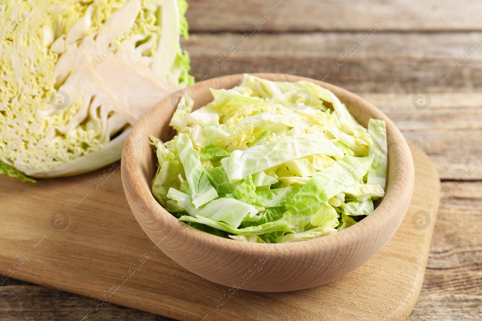 Photo of Cut Savoy cabbage on wooden table, closeup