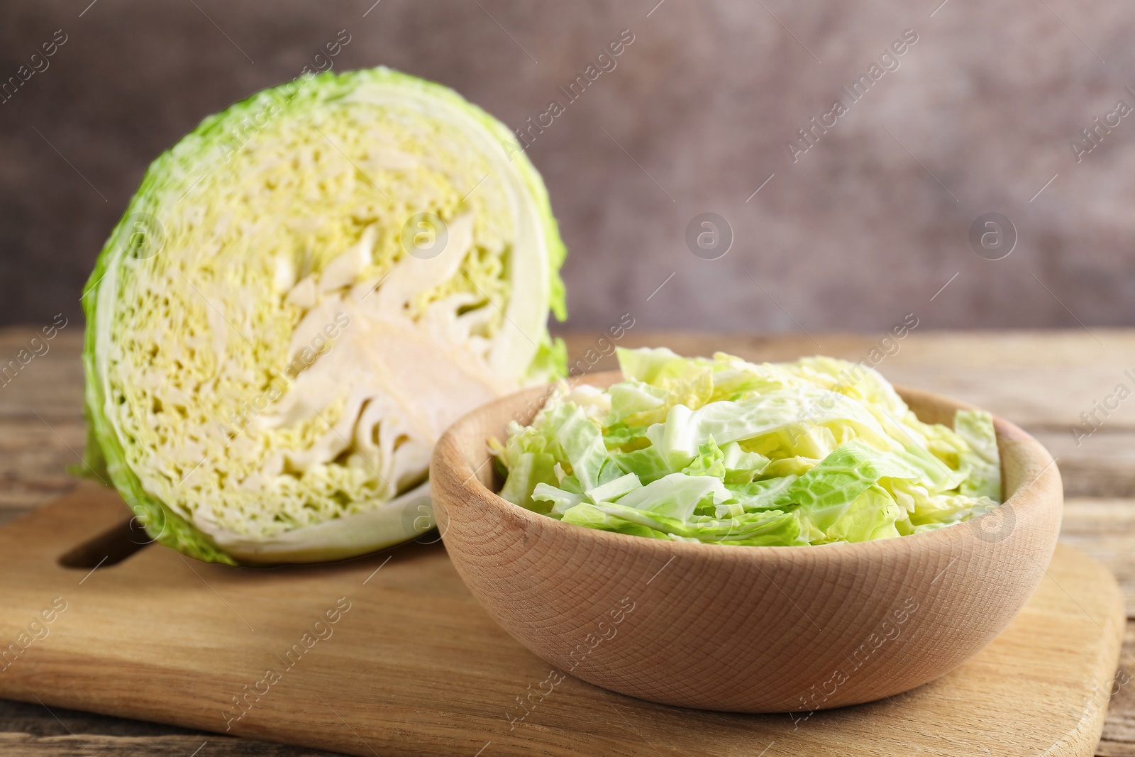 Photo of Cut Savoy cabbage on wooden table, closeup