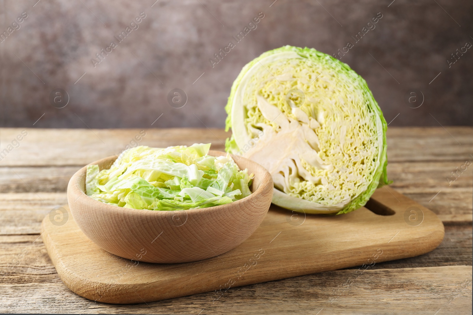 Photo of Cut Savoy cabbage on wooden table, closeup