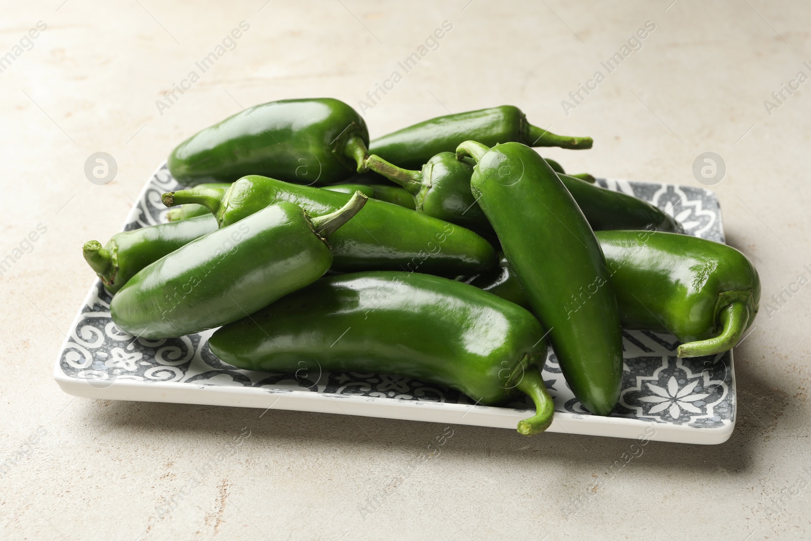 Photo of Fresh jalapeno peppers on light textured table, closeup