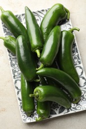 Photo of Fresh jalapeno peppers on light textured table, above view
