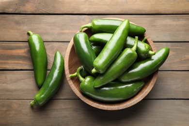 Photo of Fresh jalapeno peppers on wooden table, top view