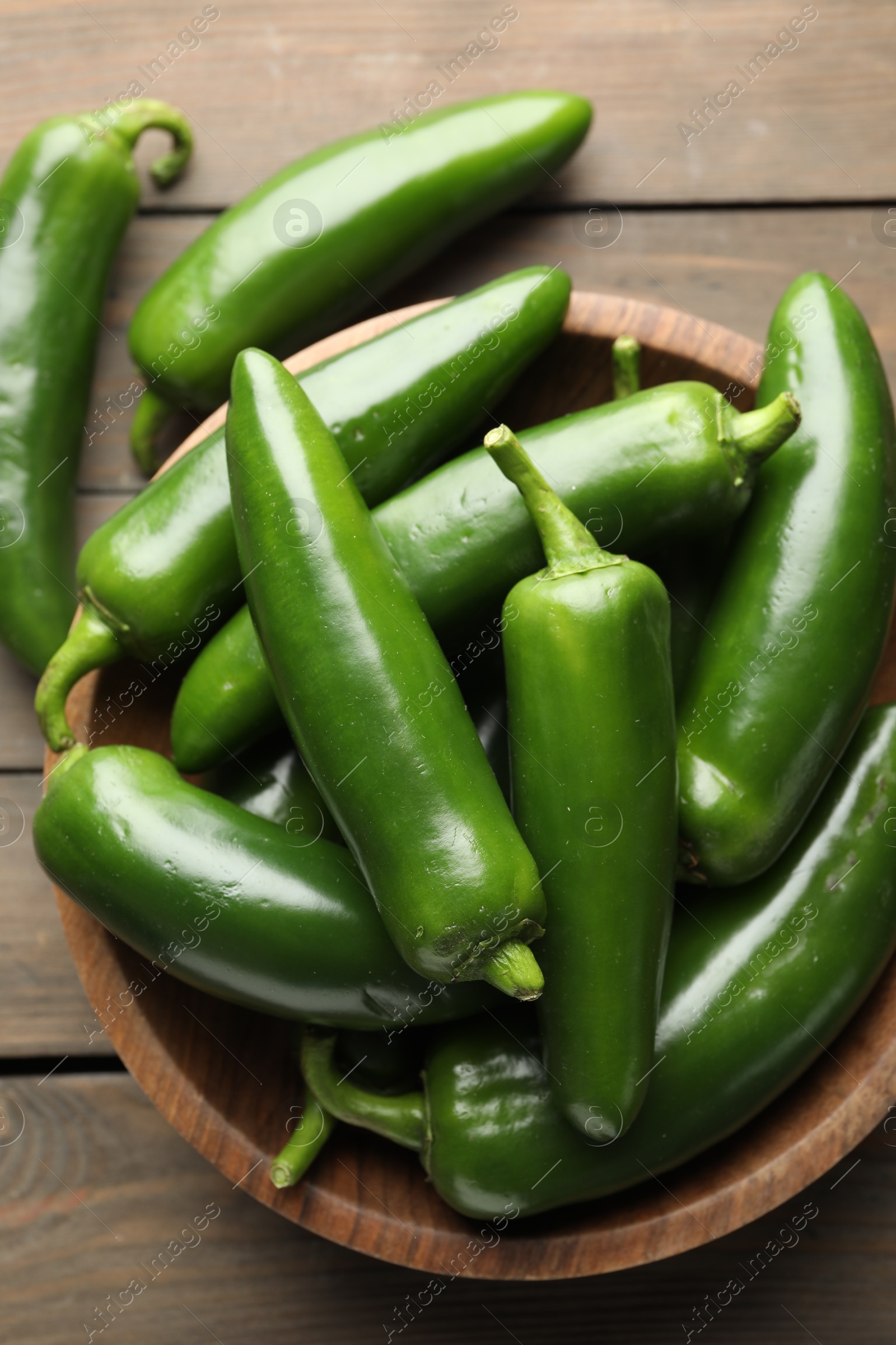 Photo of Fresh jalapeno peppers on wooden table, top view