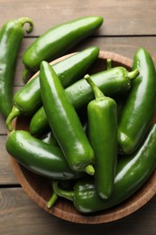 Photo of Fresh jalapeno peppers on wooden table, top view
