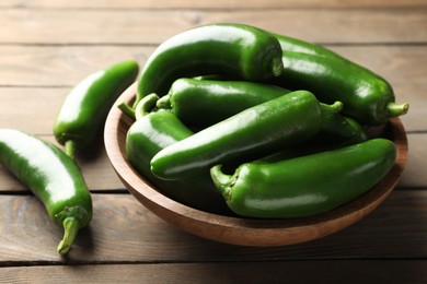 Photo of Fresh jalapeno peppers on wooden table, closeup