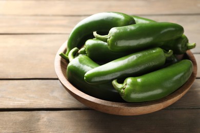Photo of Fresh jalapeno peppers on wooden table, closeup