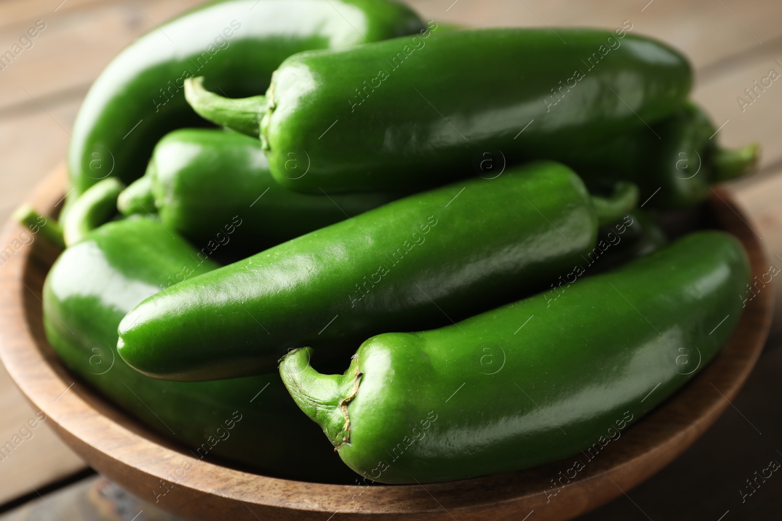 Photo of Fresh jalapeno peppers in bowl on table, closeup