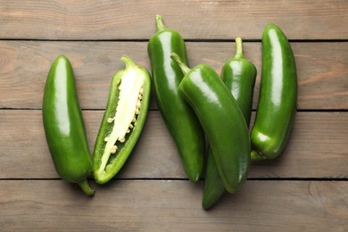 Photo of Fresh jalapeno peppers on wooden table, top view