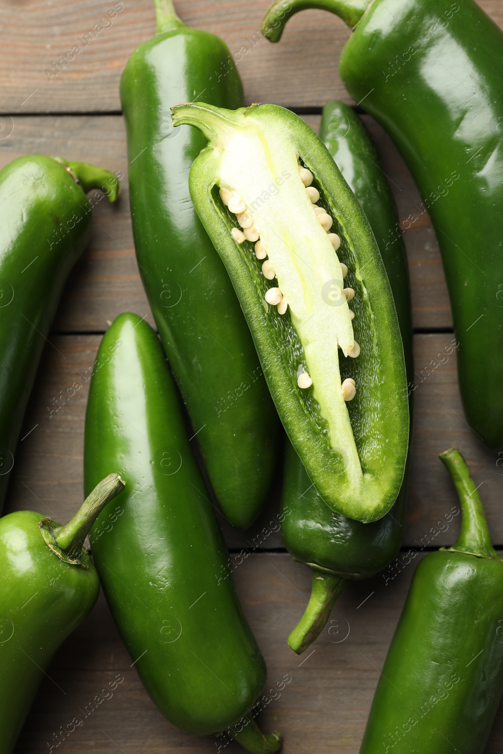 Photo of Fresh jalapeno peppers on wooden table, top view