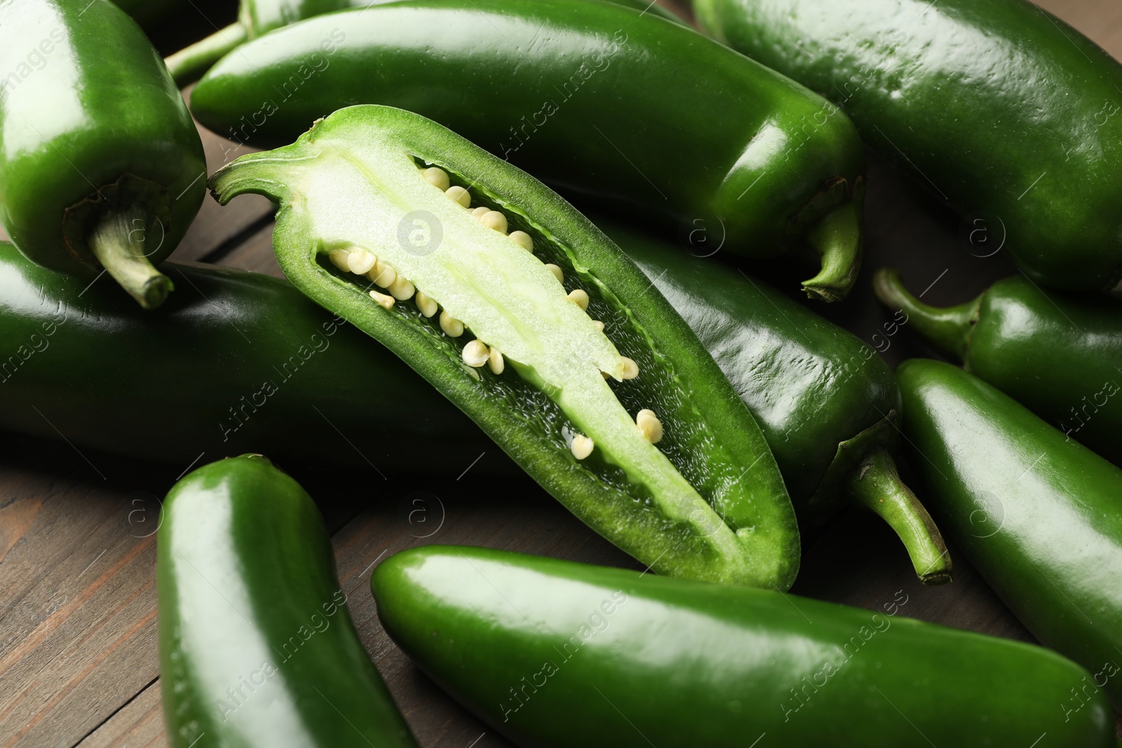 Photo of Fresh jalapeno peppers on wooden table, closeup