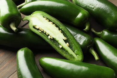 Photo of Fresh jalapeno peppers on wooden table, closeup