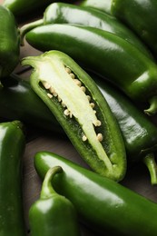 Photo of Fresh jalapeno peppers on wooden table, closeup