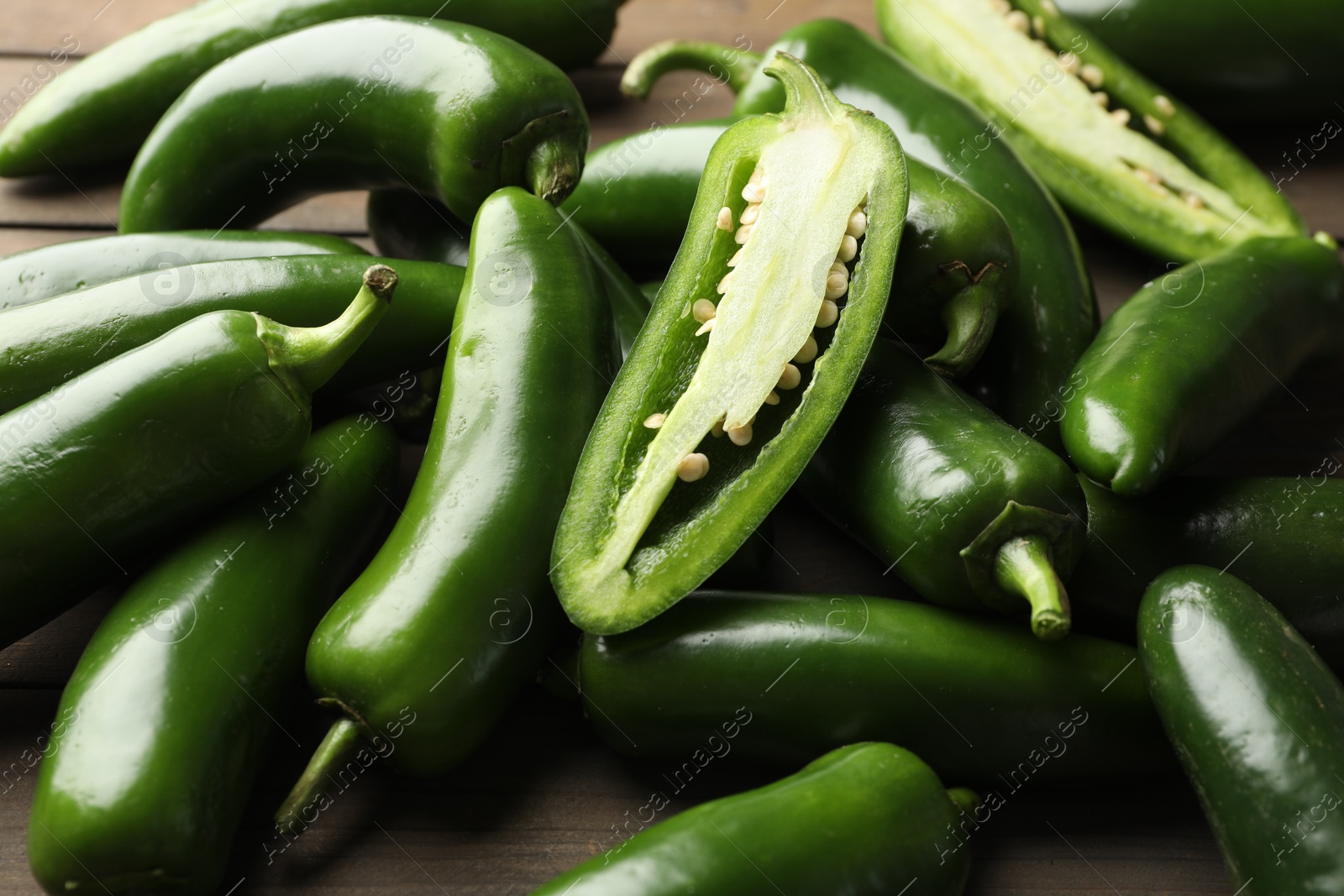 Photo of Fresh jalapeno peppers on wooden table, closeup