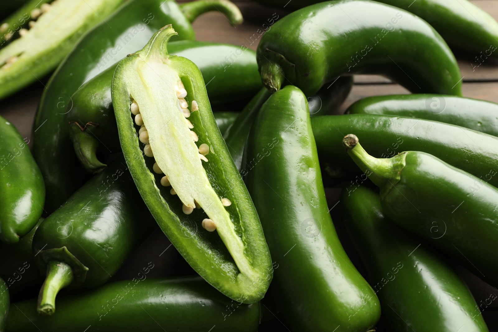 Photo of Fresh jalapeno peppers on table, closeup. Whole and cut