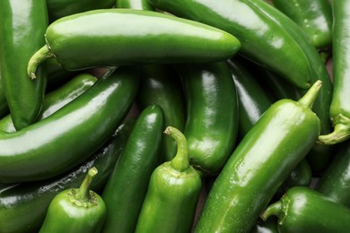 Photo of Fresh green jalapeno peppers on table, closeup