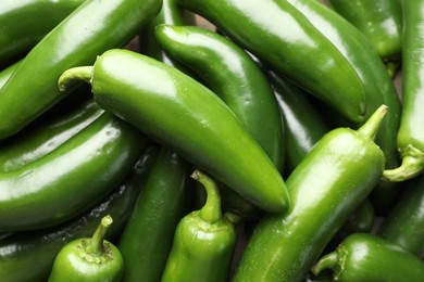 Photo of Fresh green jalapeno peppers as background, closeup
