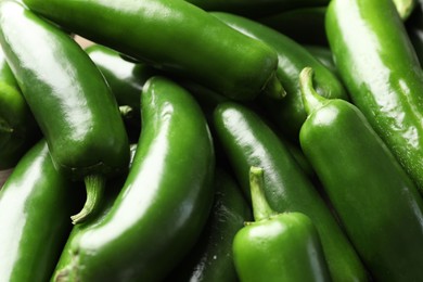 Photo of Fresh green jalapeno peppers as background, closeup
