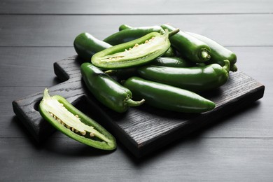 Photo of Fresh jalapeno peppers on black wooden table
