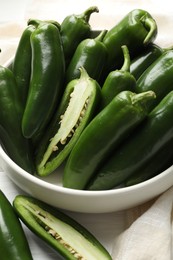 Photo of Fresh jalapeno peppers in bowl on white table, closeup