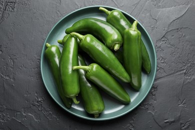 Photo of Fresh jalapeno peppers on black textured table, top view