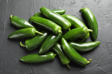 Photo of Fresh jalapeno peppers on black textured table, above view